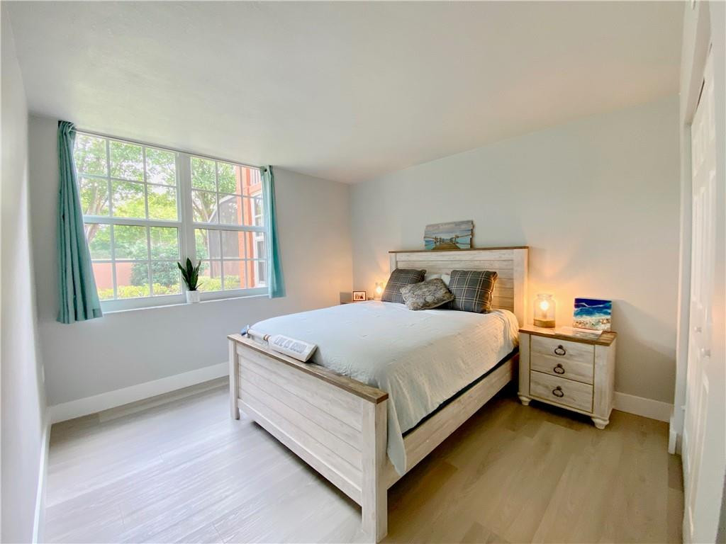 3207 Clint Moore Road, Unit 104 Boca Raton, FL 33496 - Photo 23 of 46 a bed sitting in a bedroom next to a window