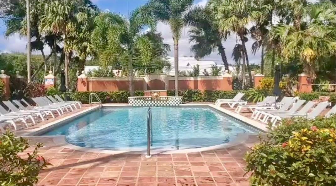 3207 Clint Moore Road, Unit 104 Boca Raton, FL 33496 - Photo 37 of 46 a view of a swimming pool with a patio