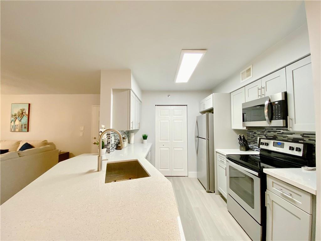 3207 Clint Moore Road, Unit 104 Boca Raton, FL 33496 - Photo 7 of 46 a bedroom with a bed and a flat screen tv