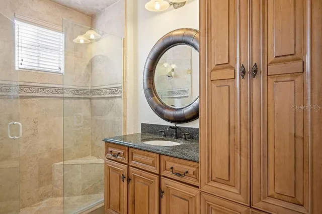 a view of a white house with a big yard and potted plants and large trees