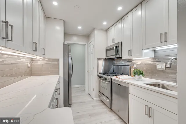a kitchen with a sink a microwave a refrigerator and cabinets