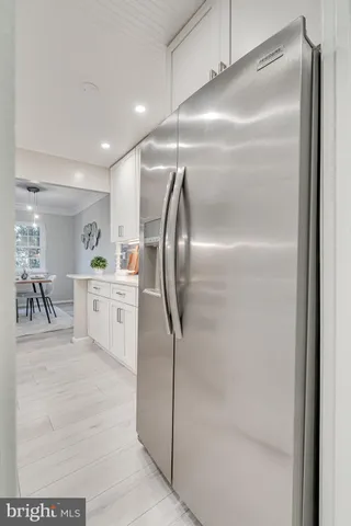 a room with stainless steel appliances kitchen island granite countertop a refrigerator and a sink