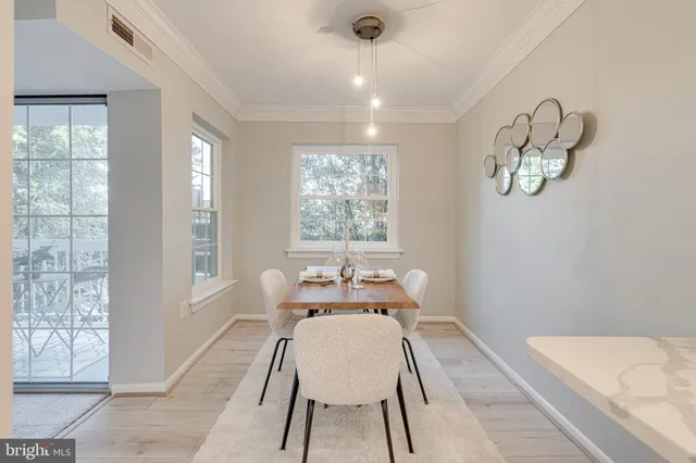 a dining room with wooden floor and a chandelier