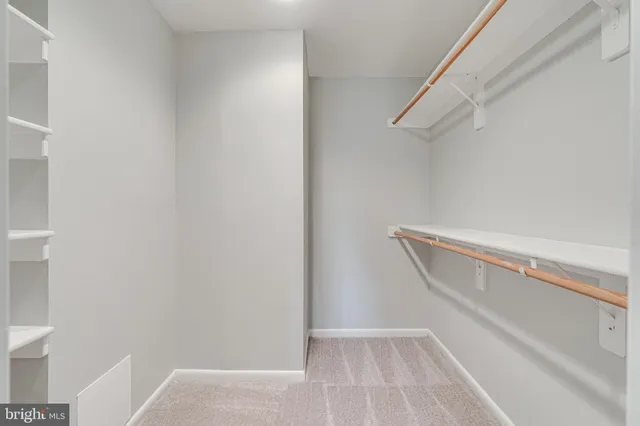 a view of walk in closet with empty racks