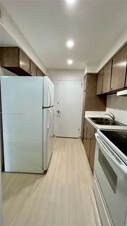 a kitchen with a refrigerator and a stove