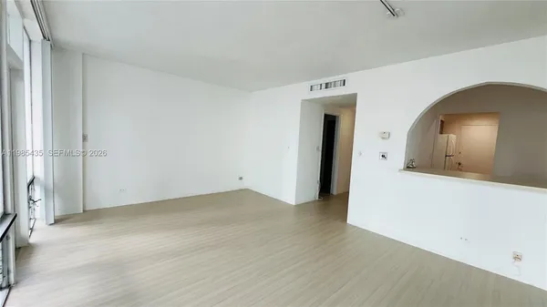 an empty room with wooden floor and mirror