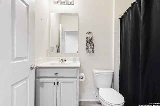 a bathroom with a toilet sink and mirror