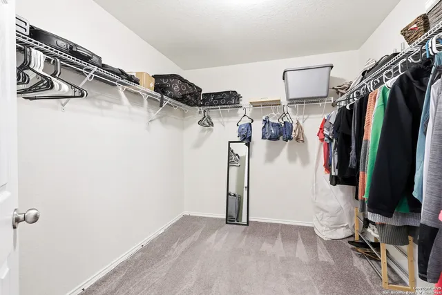 a view of walk in closet with clothes and shoes