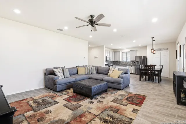a living room with furniture kitchen view and a window