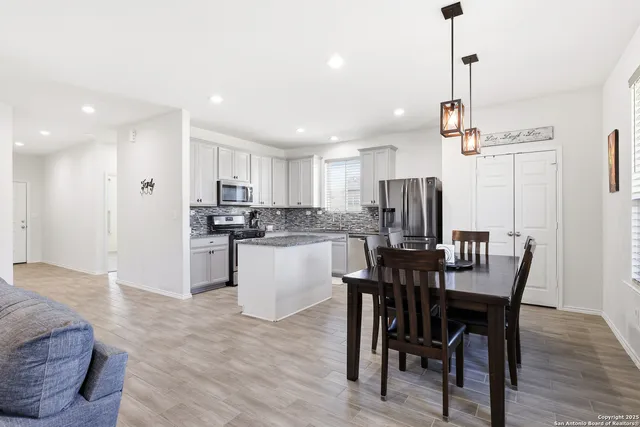 a kitchen with kitchen island wooden cabinets and refrigerator