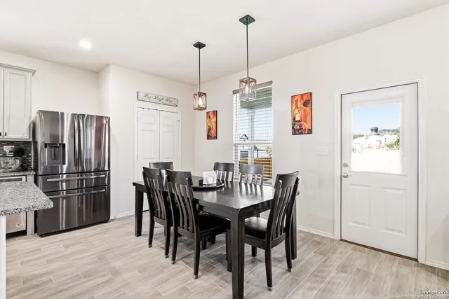 a view of a dining room and livingroom with furniture wooden floor a chandelier