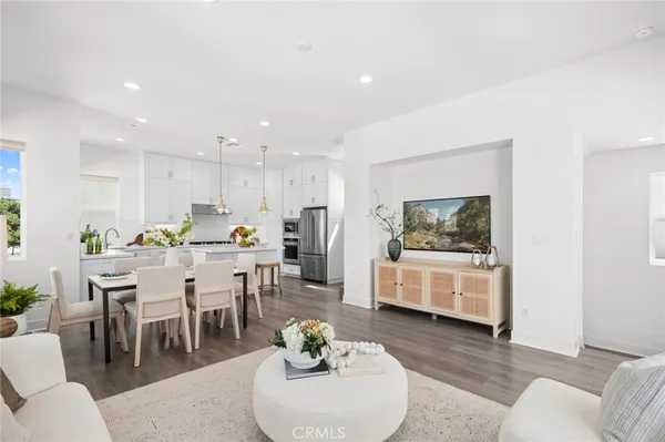 a living room with furniture kitchen view and a dining table