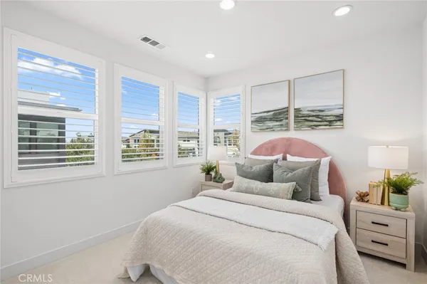 a bedroom with a bed a table and windows
