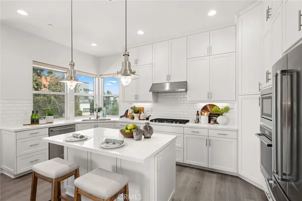 a kitchen with a sink a stove a refrigerator cabinets and wooden floor