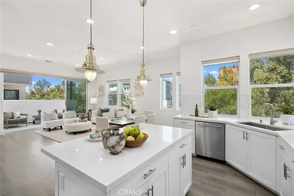 a kitchen with stainless steel appliances a sink stove and wooden floor