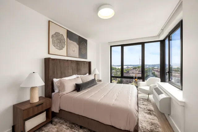 a bedroom with a bed and a large window