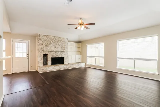 wooden floor fireplace and windows in an empty room