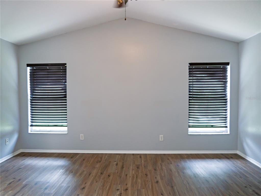 4768 Ridgemoor Circle Palm Harbor, FL 34685 - Photo 18 of 41 a view of an empty room with wooden floor and a window