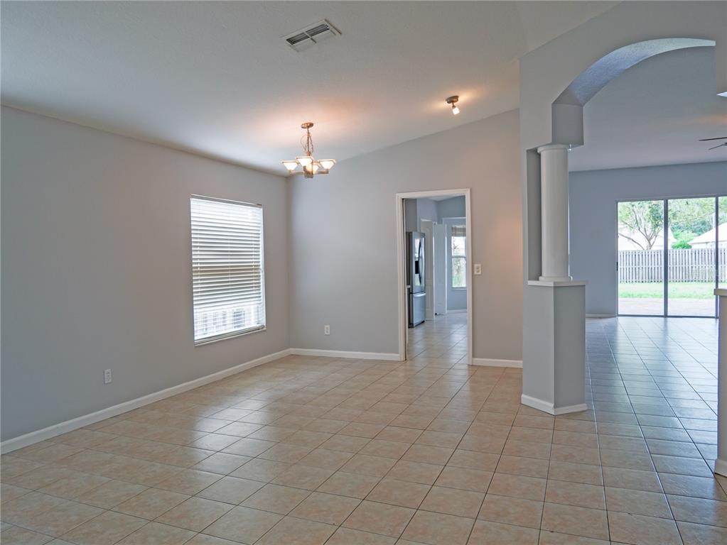 4768 Ridgemoor Circle Palm Harbor, FL 34685 - Photo 3 of 41 an empty room with chandelier and windows
