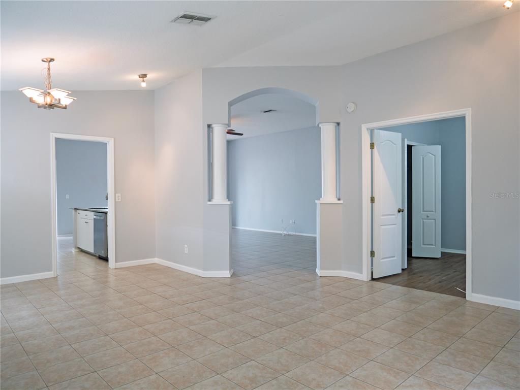 4768 Ridgemoor Circle Palm Harbor, FL 34685 - Photo 4 of 41 an empty room with chandelier fan and refrigerator