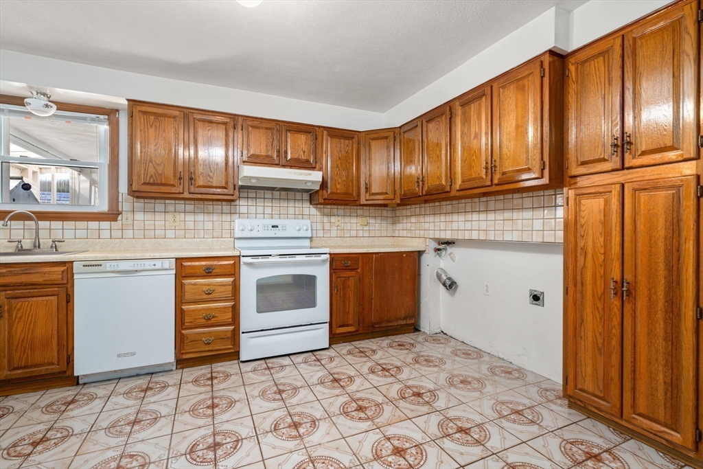 8 Sycamore Lane Saugus, MA 01906 - Photo 24 of 39 a kitchen with granite countertop cabinets and white appliances