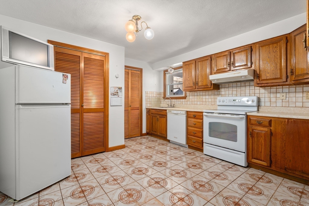 8 Sycamore Lane Saugus, MA 01906 - Photo 25 of 39 a kitchen with stainless steel appliances granite countertop a refrigerator sink and cabinets