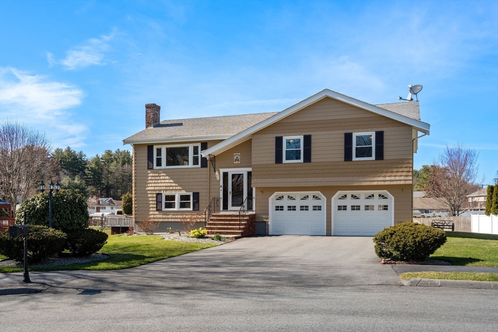 8 Sycamore Lane Saugus, MA 01906 - Photo 37 of 39 a front view of a house with a yard and garage