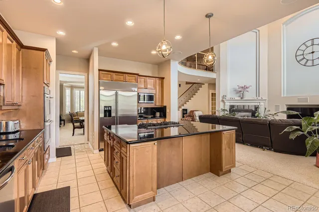 a kitchen with stainless steel appliances granite countertop a stove a sink and a refrigerator