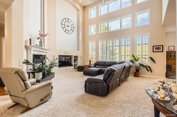 a living room with fireplace furniture and a large window