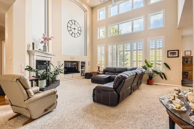 a living room with fireplace furniture and a large window