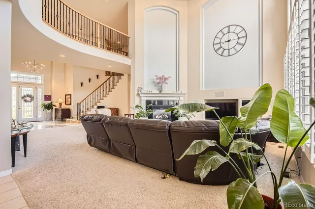 a living room with furniture a clock and a window