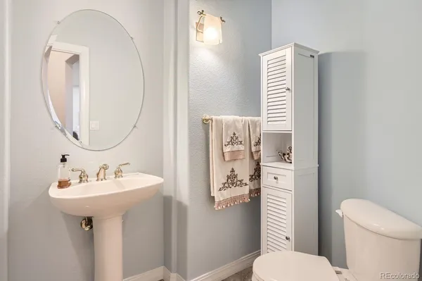 a bathroom with a sink toilet and a mirror