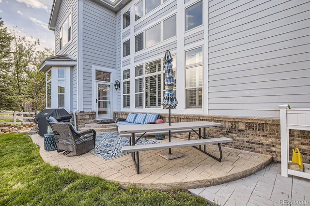a backyard of a house with table and chairs