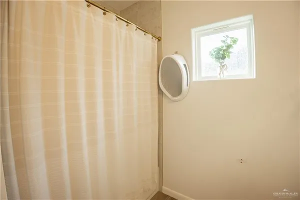 a bathroom with a shower curtain and a large window