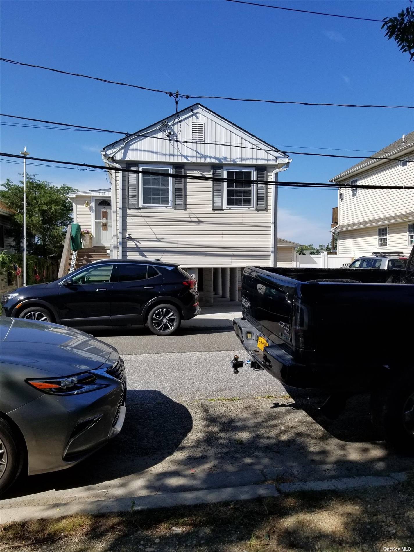 a front view of a house with cars parked