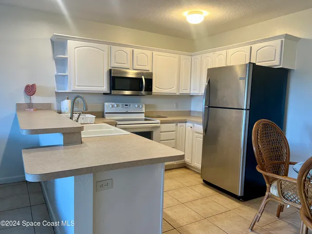 a kitchen with stainless steel appliances granite countertop a sink a refrigerator and a stove