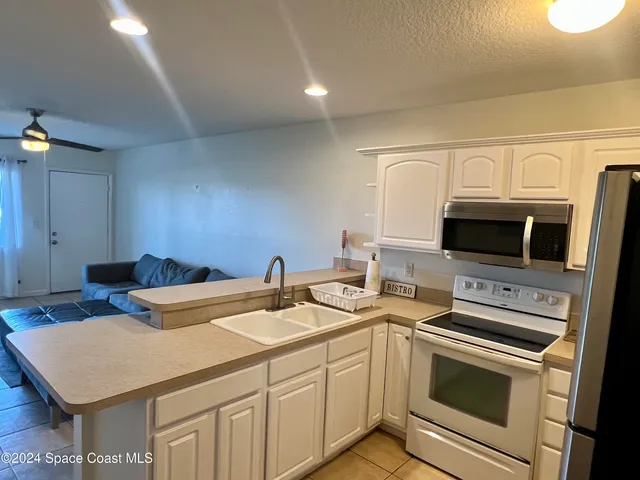 a kitchen that has a sink and a stove top oven