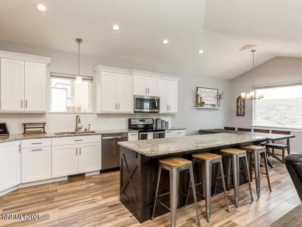 a kitchen with stainless steel appliances granite countertop a stove a sink a oven a dining table and chairs