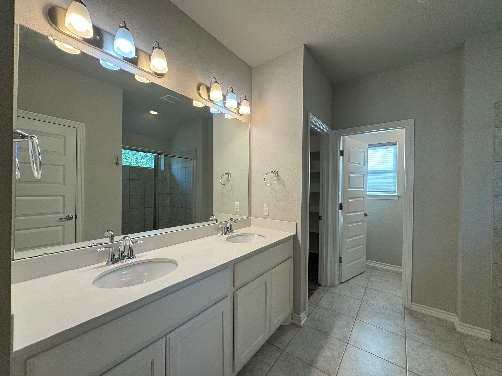 14100 McCoy Loop, Unit 1 Austin, TX 78717 - Photo 19 of 39 Dual vanities and a spacious shower elevate daily routines in this well-appointed bathroom.