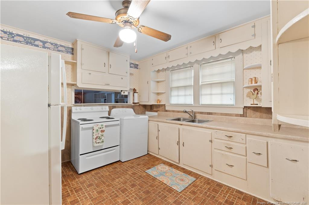 6131 Stewart Road Godwin, NC 28344 - Photo 13 of 27 a kitchen with white cabinets and white appliances