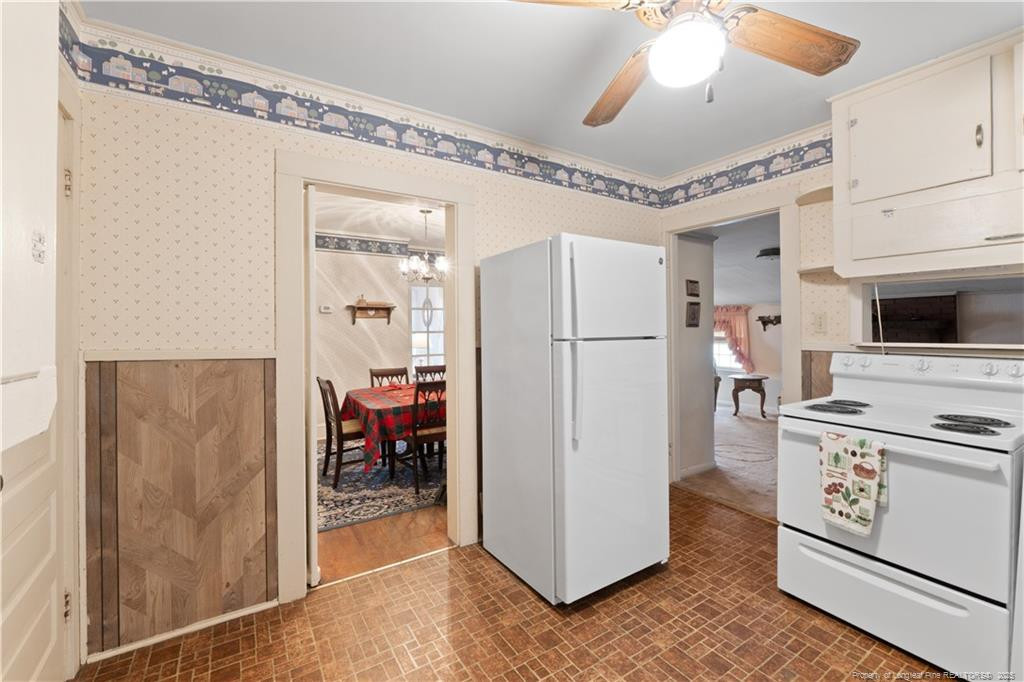 6131 Stewart Road Godwin, NC 28344 - Photo 14 of 27 a kitchen with stainless steel appliances a refrigerator a stove a microwave oven with a dining table and chairs