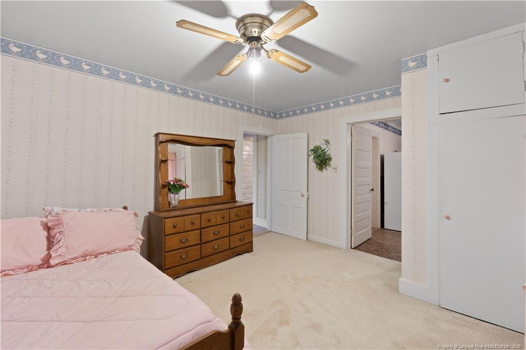6131 Stewart Road Godwin, NC 28344 - Photo 20 of 27 a bedroom with a bed and a chandelier