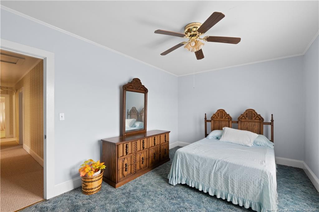 6131 Stewart Road Godwin, NC 28344 - Photo 23 of 27 a bedroom with bed and a chandelier
