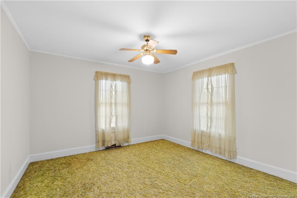 6131 Stewart Road Godwin, NC 28344 - Photo 25 of 27 an empty room with windows and chandelier fan