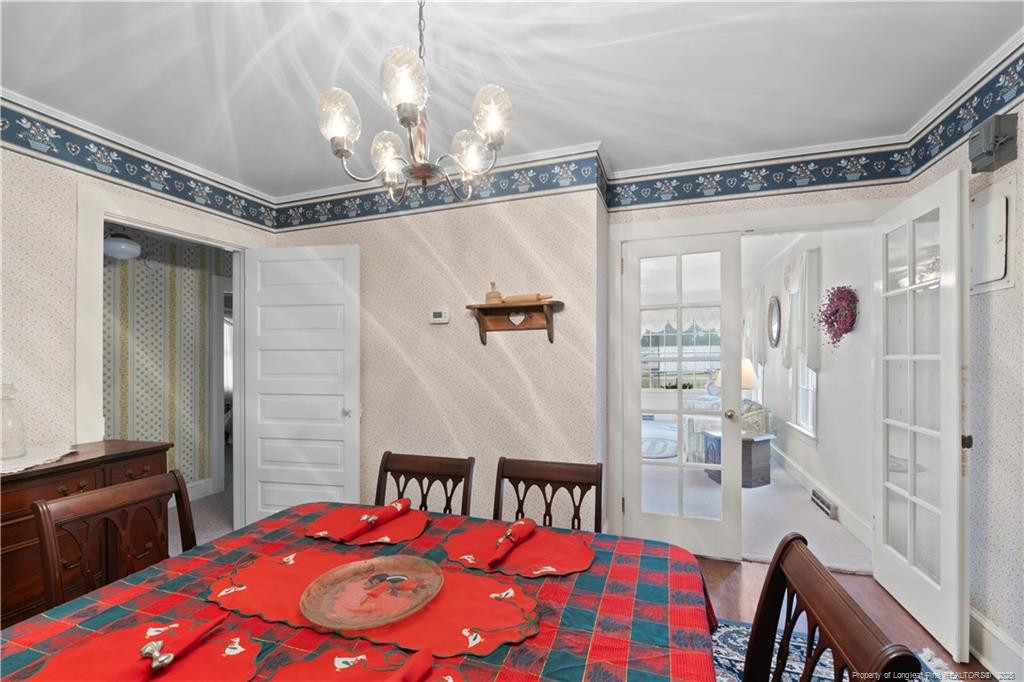 6131 Stewart Road Godwin, NC 28344 - Photo 10 of 27 a bedroom with a bed a chandelier and a dresser