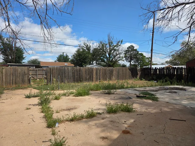 a view of a backyard with wooden fence
