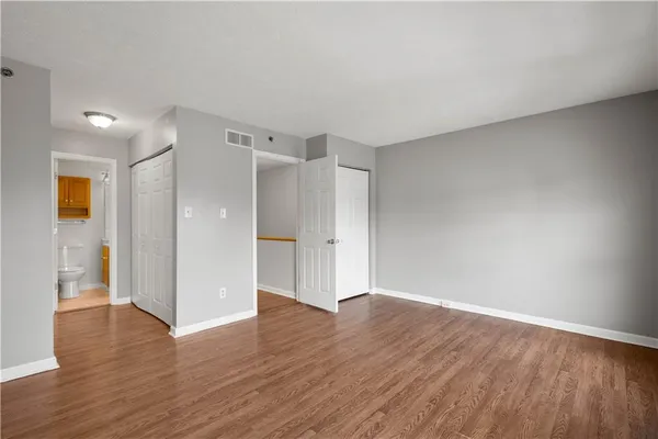 a view of an empty room with wooden floor