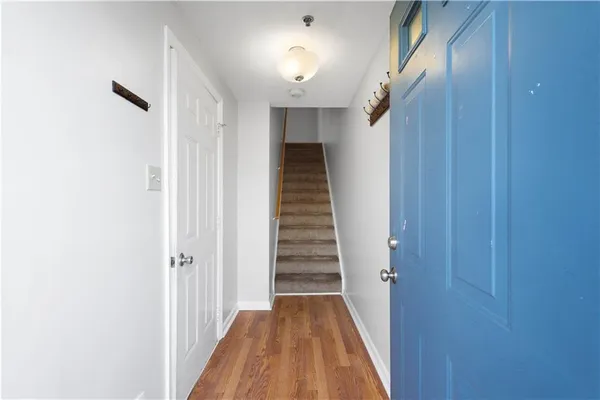 a view of a hallway with wooden floor and staircase