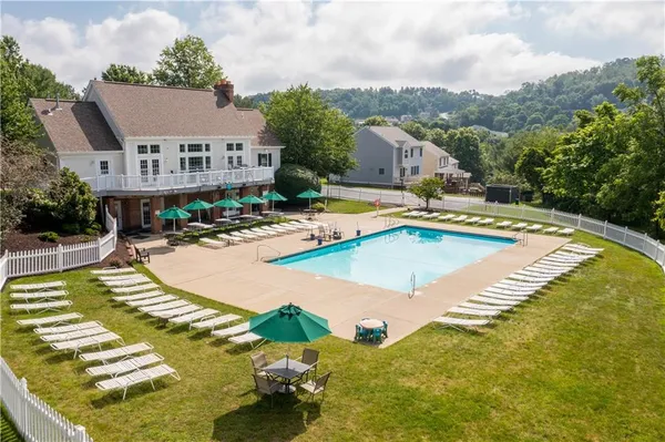 a view of an empty room with wooden floor fireplace and a window