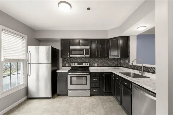 a kitchen with a sink stainless steel appliances and cabinets
